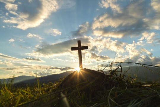 The wooden cross on tomb of the dead at sunset background