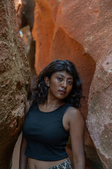 A woman stands in a cave with her back to the camera