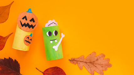 Naklejka premium Halloween monsters from toilet paper roll tube, easy DIY handmade decorations idea. Paper toys zombie and vampire on yellow background. Kids creativity, easy eco craft, step by step, place for text