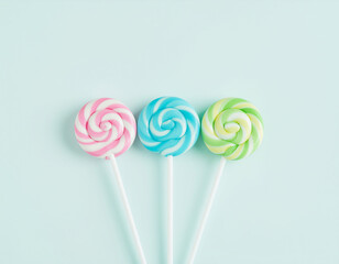 Minimal sweet composition with three pastel lollipops
