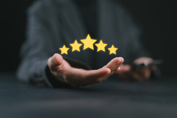 hand of customer or client holding the stars to complete five stars. with copy space. giving a five star rating. Service rating, satisfaction concept.
