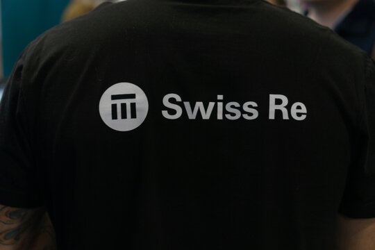 Bratislava, Slovakia, Europe - Oct 16, 2025: close up of the back of a black t shirt featuring the white swiss re company logo and text concept of corporate branding, financial services, business