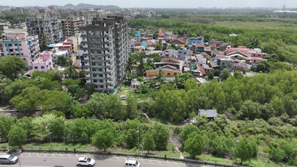 High-resolution aerial photograph showcasing a vibrant coastal city in India, bordered by dense...