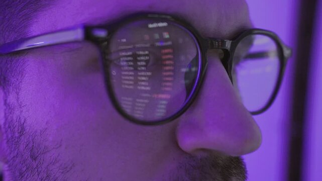 Excited young male stock market broker looking at graph on computer