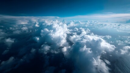 Obraz premium Expansive aerial view of dramatic clouds floating above the deep blue ocean under a clear sky