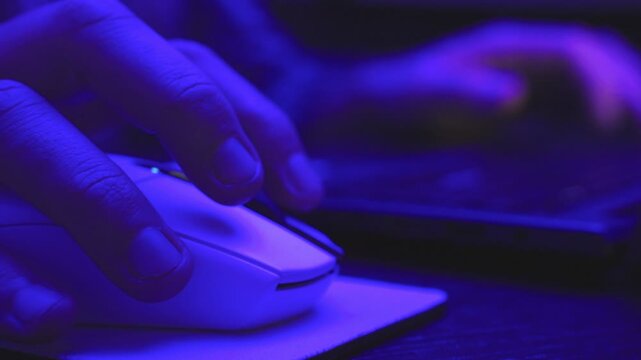 Man browsing in internet while clicking mouse and typing on the keyboard