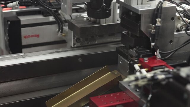 Close-up of an industrial robotic system featuring a gripper, sensors, and automated mechanical components on a production line. No visible branding or logos