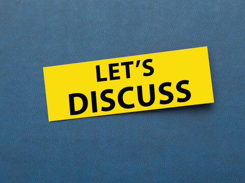 lets discuss. business or education concept. text on a sticker on a blue background