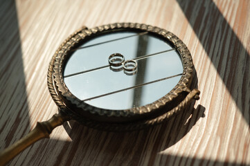 Vintage mirror with wedding rings reflection