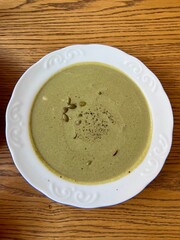 Pumpkin and broccoli puree cheese soup served on a beautiful, elegant plate