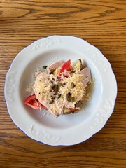 Salad with chicken breast, cheese and tomatoes on an elegant plate
