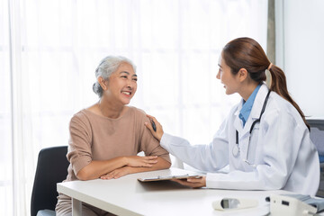 Fototapeta premium Doctor comforting elderly patient during medical consultation, discussing health with compassion and trust in a bright office