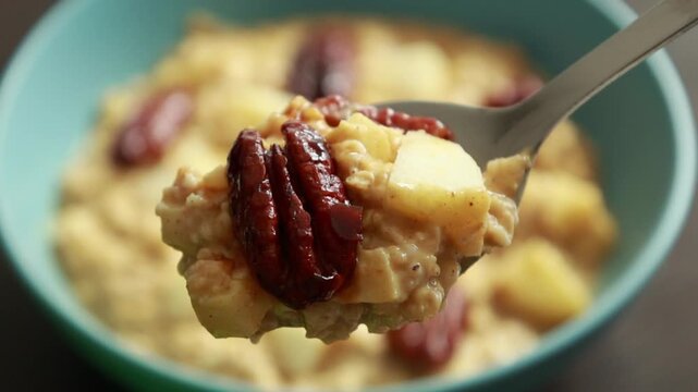 creamy pumpkin oatmeal topped with fresh apple slices and caramelized pecans