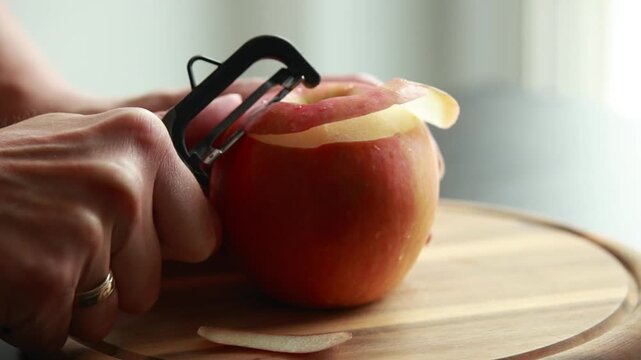 woman hands peeling fresh apple close up