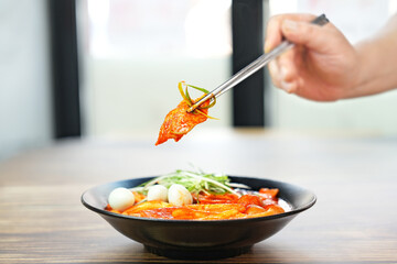 국물 떡볶이를 젓가락으로 한 점 집은 모습을촬영하였습니다.