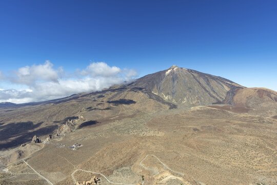 Panorama during the ascent to the Alto de Guajara, 2715m, to the bizarrely shaped rock formations of volcanic rock, Roques de Garc&iacute;a, the visitor centre and the Hotel Parador, behind it the Pico del Teide, 3717m, at sunrise, Teide National Park, Parque Nacional del Teide, Tenerife, Canary Islands, Spain