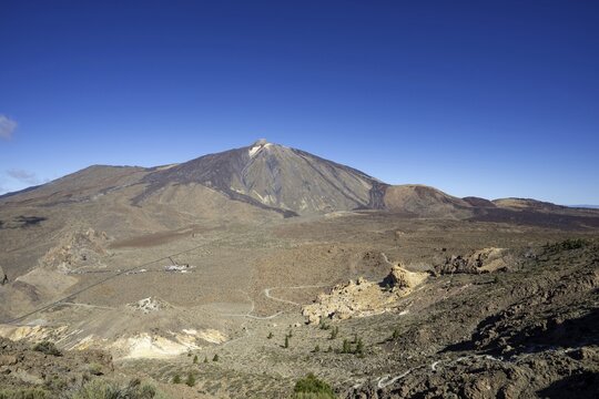 Panorama during the ascent to the Alto de Guajara, 2715m, to the bizarrely shaped rock formations of volcanic rock, Roques de Garc&iacute;a, the visitor centre and the Hotel Parador, behind it the Pico del Teide, 3717m, at sunrise, Teide National Park, Parque Nacional del Teide, Tenerife, Canary Islands, Spain