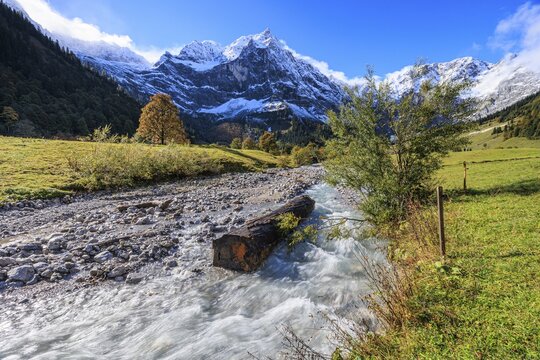 Wild river in front of snow-covered mountains, autumn, maple trees, sunny, Engalm, Gro&szlig;er Ahornboden, Karwendel Mountains, Tyrol, Austria