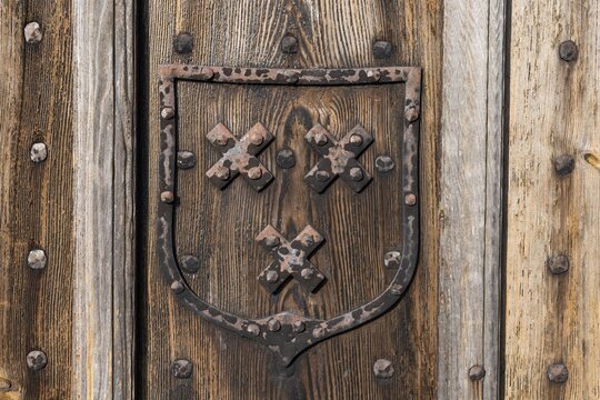 Old wooden door with hand-forged fittings, coat of arms, former Hanseatic city of Visby, UNESCO World Heritage Site, Gotland Island, Sweden