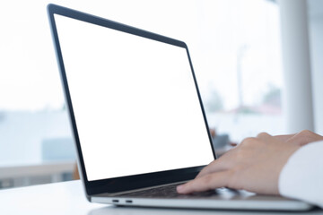 Close-up of hands using laptop with blank white screen in bright office environment, perfect for website mockups, UI/UX presentation, remote work, digital design, or online content creation.