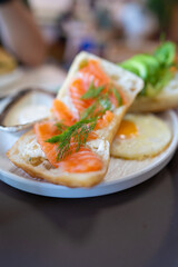 Open sandwich with smoked salmon, cream cheese, dill, and fried egg, fresh greens