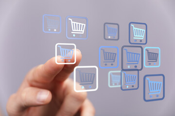 Hand pressing a digital shopping cart icon. Concept of online shopping, e-commerce, and digital transactions. Represents buying, selling, and ad