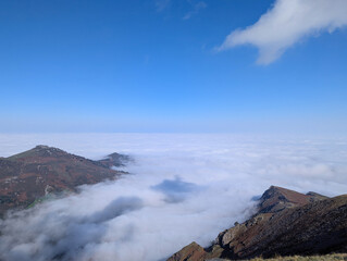 Panorama deslumbrante do outono nas montanhas de Artzamendi em Itxassou, com um manto de neblina sob um céu azul em França © LuIvDa