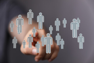 Hand reaching toward human icons, symbolizing connection, teamwork, and digital interaction.  Represents concepts like networking, social media,