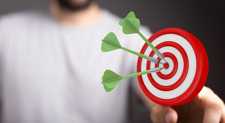 Concept of achieving a target. Hand throwing darts at a bullseye. Success, precision, goals,...