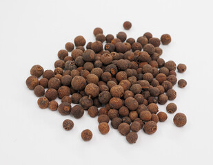 Pile Of Brown Allspice Berries On White Background For Cooking, Spice, And Food Photography