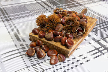 A pile of chestnuts on a wooden board