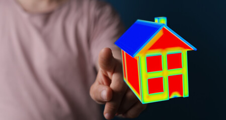 Conceptual image of a hand pointing at a 3D house model. Represents property, homeownership, real estate, construction, and dreams of the future