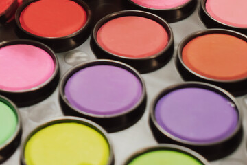 Abstract macro of a colorful paint palette: vibrant pink, orange, and yellow cells