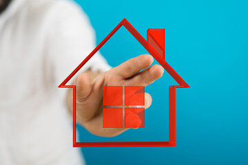 A hand reaching towards a red house outline, symbolizing home ownership, dreams, and investment....