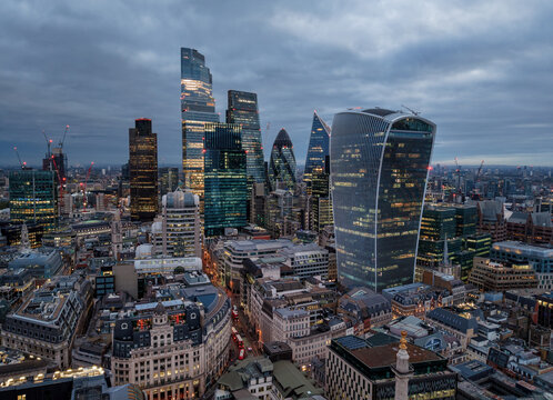 Aerial view of the illuminated office skyscrapers at the City cluster in London during a moody autumn morning