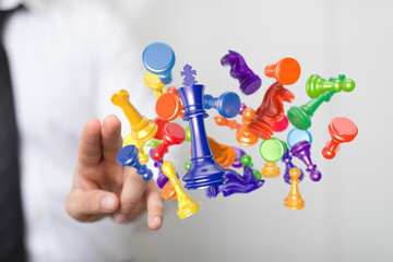 Abstract image of floating chess pieces controlled by a hand. Strategic thinking concept with colorful chessmen. Business planning and control.