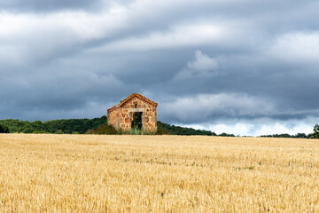 petite maison ancienne de vignerons au milieu d'un champ proche d'issoire dans le puy de d&ocirc;me par une journ&eacute;e orageuse avec un ciel gris toument&eacute;