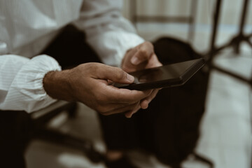 Obraz premium Focus on a person's hand using a mobile phone.