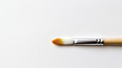 Brush with fine tip ready for painting on clean canvas in a creative studio environment