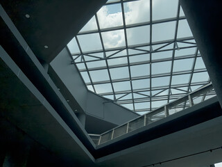 Modern architectural marvel features a stunning glass ceiling and geometric steel structure bathing the interior in natural light, located in Yogyakarta Indonesia.