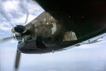 Close-Up of Airplane Engine with Spinning Propeller in Flight. Detailed close-up view of an aircraft engine with a spinning propeller in motion against the blue sky.