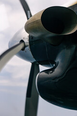 Close-up view of an airplane turboprop engine and propeller blades during flight. Aviation background with metallic textures and engineering details.