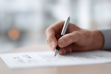 Closeup of a hand signing a document with a pen. Represents agreement, contract, signing, or writing. Ideal for business, legal, or educational concepts.