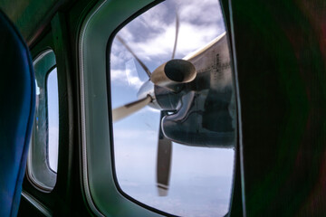 Airplane Propeller and Landscape View from Window. View of an aircraft propeller in motion seen from the passenger window.