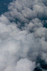 View of White Clouds from Airplane Window. Beautiful aerial view of soft white clouds from an airplane window during flight. The peaceful atmosphere of the sky above the clouds.