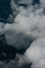 View of White Clouds from Airplane Window. Beautiful aerial view of soft white clouds from an airplane window during flight. The peaceful atmosphere of the sky above the clouds.