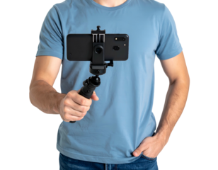 Man in blue tee holding a black phone in a tripod, against a black background