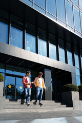 Men discussing business walking down office building stairs