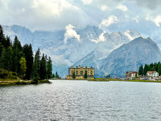 Aerial view of breathtaking landscape of Lake Misurina and hotel. Dolomites mountain in background, IAlpine lake in the Italian Alps. Drone view of Lago di Misurina. Mountain forest lake with a view.