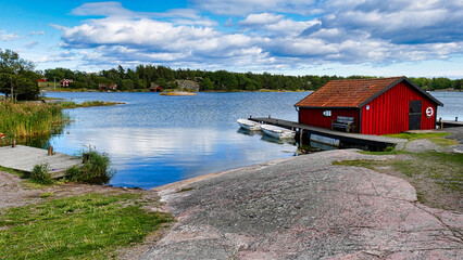 Bootshaus mit Anlegesteg und Booten in der Sch&auml;renlandschaft des Naturreservats Stend&ouml;rren in Schweden